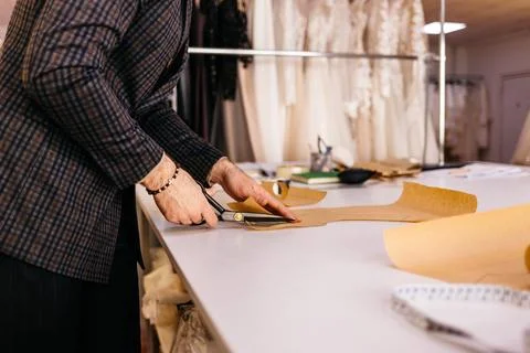 Tailor working at studio cutting fabric, detail of hand with scissors Fotos de archivo