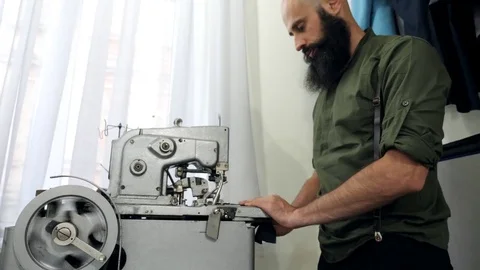 A Tailor works on his eyelet buttonhole machine. Stock Footage