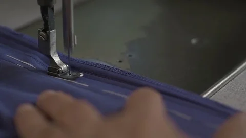 A tailor works on sew machine in slow motion Stock Footage