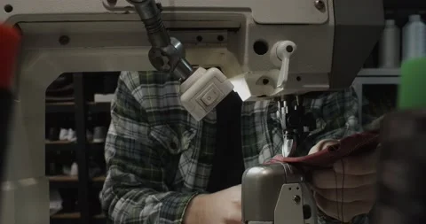 Tailor works on sewing machine in private leather craftshop, making shoes in Video stock 200127298