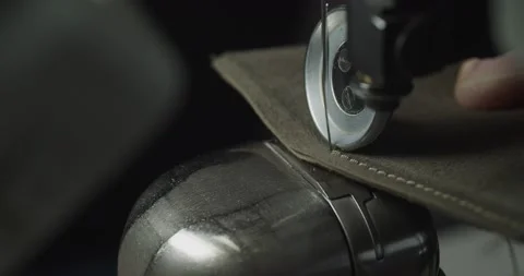 Tailor works on sewing machine in private leather craftshop, making shoes in Stock Footage 200127439