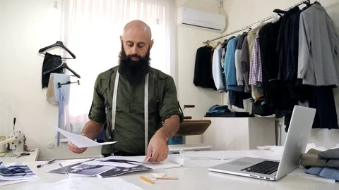 Tailor works with sketches in his workshop. Video stock 80733291