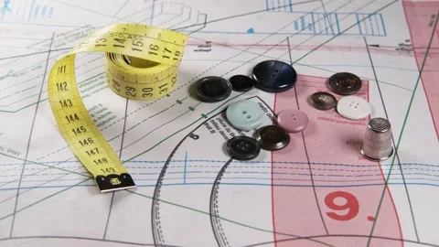 Tailoring accessories, measuring tape, buttons, patterns, on work table Видео 148180476