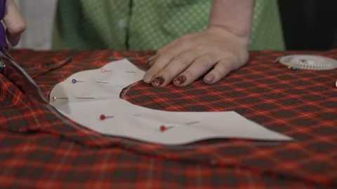 Tailoring concept. Dressmaker cutting chequered fabric with tailor scissors. Stock Footage 88757035