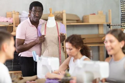 Tailoring instructor demonstrating garment construction in adult sewing class Stock Photos