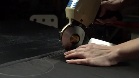 Tailoring process. Cutting cloth with electric circular knife Stock Footage 104539909