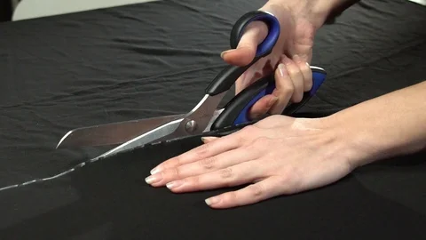 Tailoring process. Cutting the cloth with scissors in slow motion Stock Footage 104540016