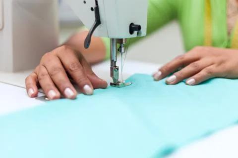 Tailoring Process - Women's hands behind her sewing machine tailor Stock Photos