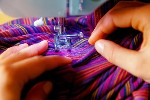 Tailoring Process - Women's hands behind her sewing. purple fabric. Foto stock