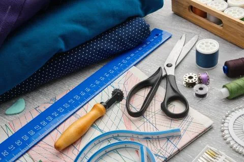 Tailoring scissors, measuring tape, threads, patterns. Stock Photos