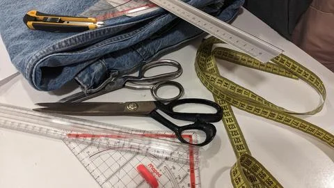 Tailoring tools: jeans, ruler, scissors, knife, blade and jeans Foto stock