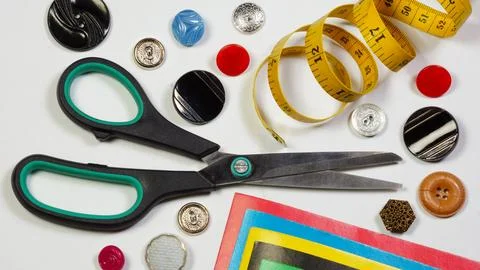 Tailor's background made of scissors, measuring tape and buttons. Stock Photos