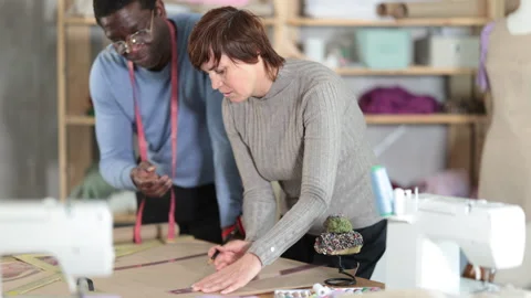 Tailors drafting new clothing pattern on paper in sewing workshop 스톡 동영상 330042755