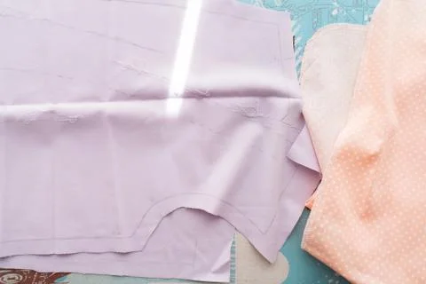 A tailor's work table with cloth for a cut and marked up for sewing. Stock Photos