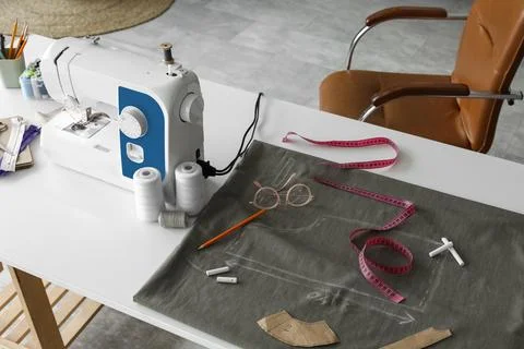 Tailor's workplace with sewing machine and thread spools in atelier Stock Photos