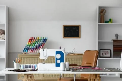 Tailor's workplace with sewing machine and thread spools in atelier Stock Photos
