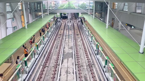 Taipei MRT train arrival at Siwei Elementary School Station overhead view with Stock Footage 334576793