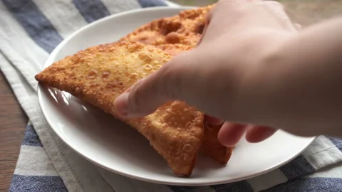 Take a bite of roasted chebureki on a plate, Uzbek national dish. Asian fried me Stock Footage 132509567