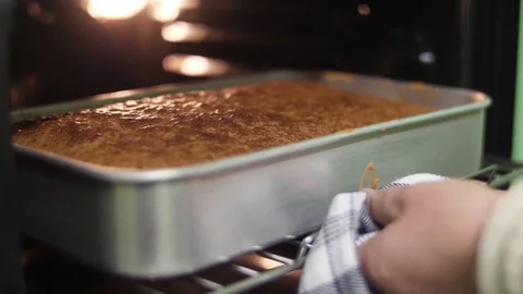Take cake form from oven slow motion  Stock Footage 84916633