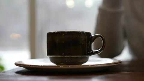 Take a cup of tea with hot tea or coffee, roll it on a cup and pick it up. slow Stock Footage 82835584