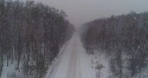 Take off on a drone over a winter forest road Stock Footage 147678461