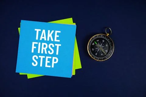 Take First Step text written on sticky note with compass on blue  background Stock Photos
