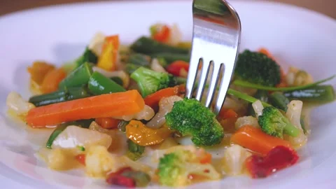 Take a fork of cooked vegetable on white dish. A mixture of carrots, broccoli Stock Footage 144260888