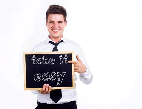 Take it easy - Young smiling businessman holding chalkboard with text Stock Photos