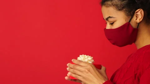 Take it. Side view of guy giving a gift with ribbon to his girlfriend. Young Stock Footage 146128926