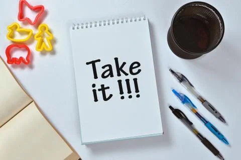 Take it text on notepad with office accessories Stock Photos