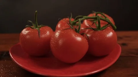 Take one ripe tomato from a red plate, and then put back Vidéo 72213770