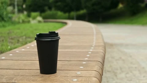 Take-out coffee cup. Paper cup with hot drink in city park close up Stock Footage 194537879