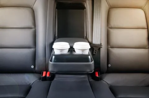 Take out coffee cups inside car holder between seats, close up view, sun light Stock Photos
