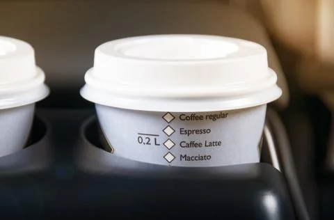 Take out coffee cups inside car holder between seats, close up view, sun light Stock Photos
