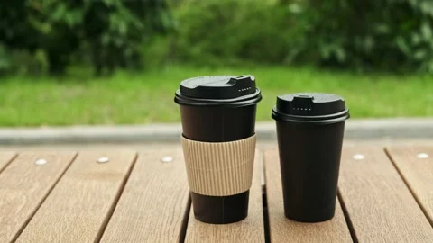 Take-out coffee cups. Paper cups with hot drink in city park close up Stock Footage 194537895