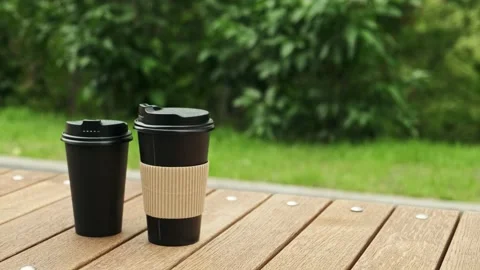 Take-out coffee cups. Two paper cups with hot drink in city park close up Stock Footage 194537923
