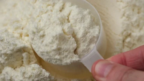 Take out a measuring spoon filled with white protein powder Stock Footage 282443479