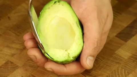 Take out the pulp of avocado with a spoon Stock Footage 73482870