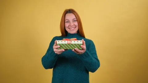 Take this present. Charming happy young woman giving wrapped gift box to camera Stock Footage 148492203