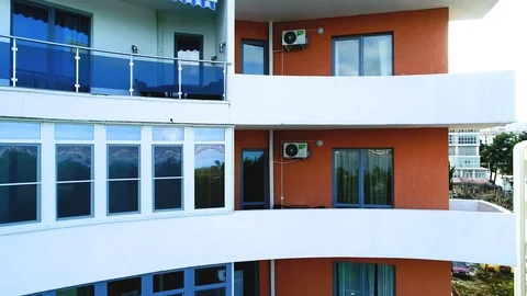 Take-off of a quadrocopter in front of the glass facade of a multi-storey Stock Footage 128206364