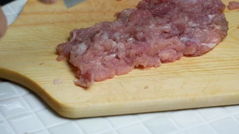 Take a sharp knife to chop pork , minced pork on wooden chopping board , prep Stock Footage 89294696
