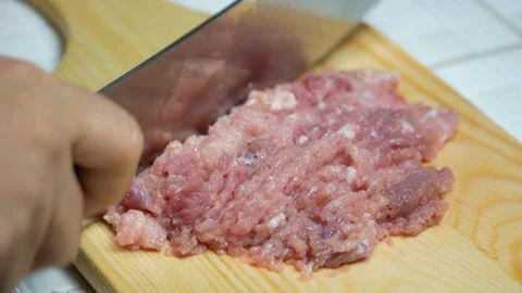 Take a sharp knife to chop pork , minced pork on wooden chopping board , prep Stockbeeldmateriaal 89294723