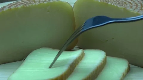 Take smoked cheese slice with a fork Stock Footage 80633867