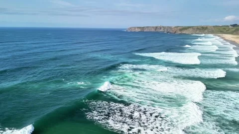 Take in the Stunning Aerial View of the Rolling Ocean Waves and the Scenic Beach Stock Footage 308404466