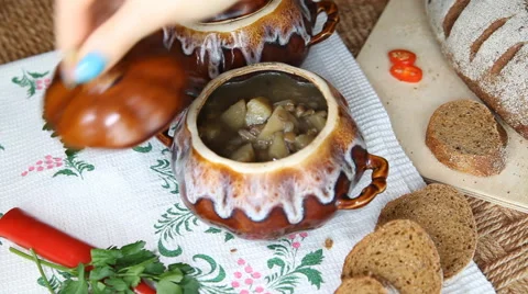 Take off the table the painted pot with vegetarian soup. Stock Footage 61949017