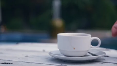 Take from the table by the pool a white cup with an invigorating coffee. slow Stock Footage 87208985
