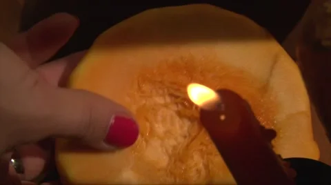 Take the top part of halloween pumpkin of he table, candle on foreground Stock Footage