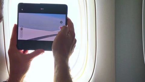 Take video from plane window on mobile phone. Shoot videos on a mobile phone. Video stock 307374699