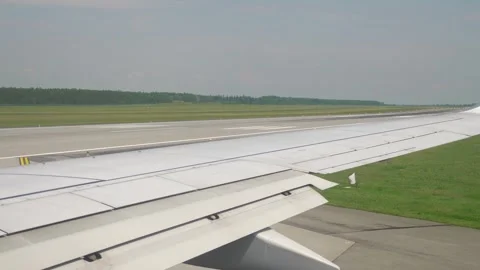 Take off view from an airplane window, showing the wing and the runway in 4.. Stock Footage 280342057