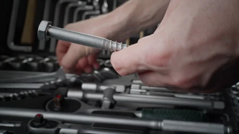 Take a wrench from the tool kit to screw a long bolt into the wall to install Stock Footage 263598744